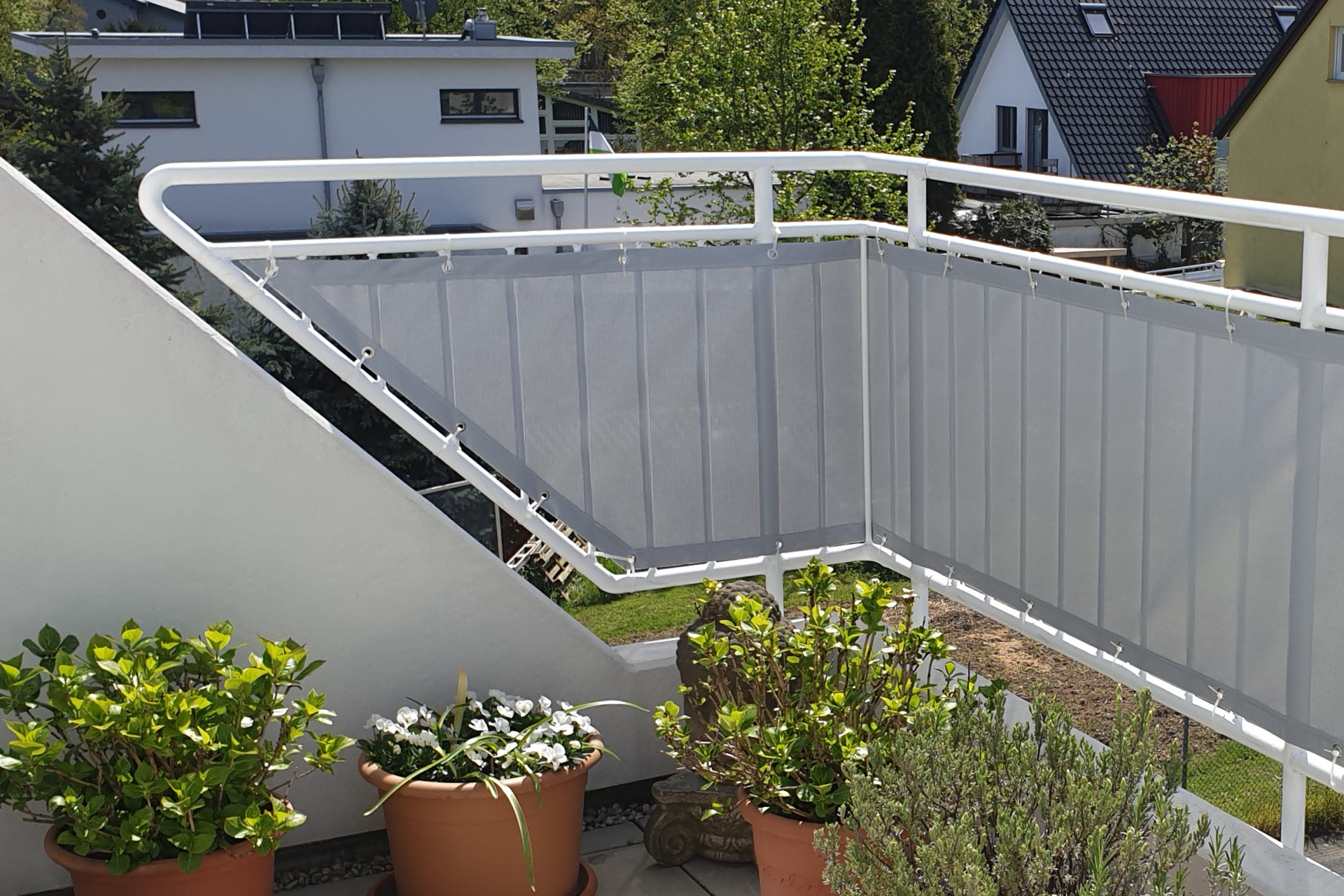 Ein Sonnensegel überdeckt eine Terasse und hüllt sie in ein angenehmes Licht